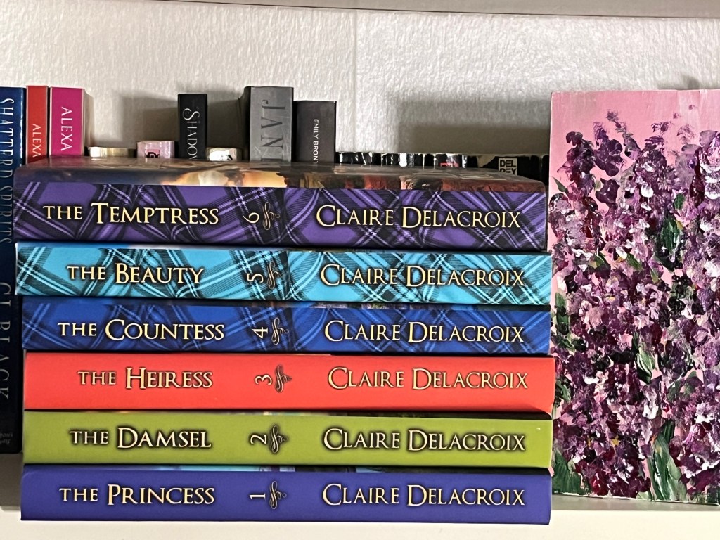 Stack of books on a bookshelf. Books are The Princess, The Damsel, The Heiress, The Countess, The Beauty, and The Temptress all by Claire Delacroix.